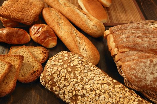 Varied bread still life over dark wood background