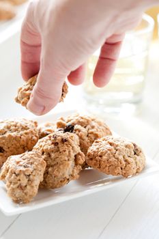 Delicious oatmeal raisin cookie being taken of the plate