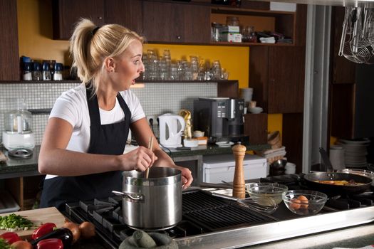 Female chef looking shocked while stirring in the pan