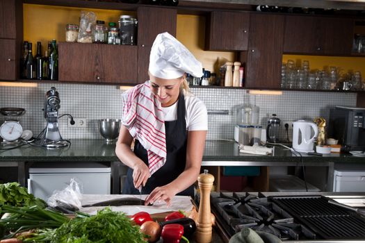 Female chef preparing to cut the head of the trout