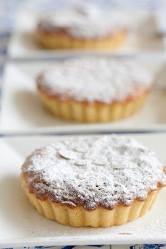 Freshly baked bakewell tarts in a row