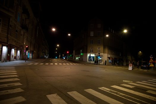 An intersection at night, with pedestrian crossing.