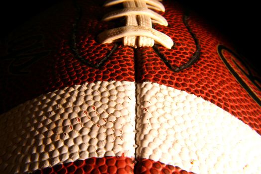 A closeup of an American Football, low key