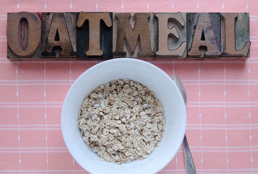 bowl of raw oatmeal with the word 'oatmeal' in old wood type