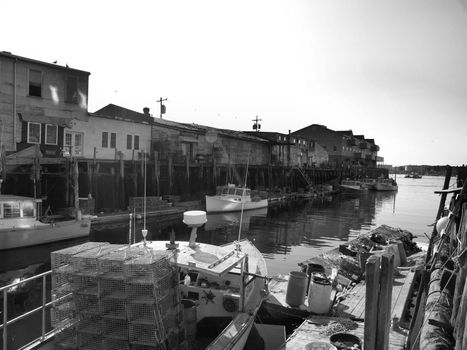 A working lobster boat along the dock in Portland, Maine during the summer. Shown in black and white