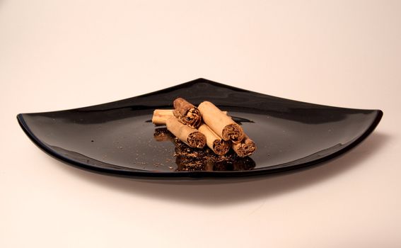 Pieces of cinnamon on a black plate