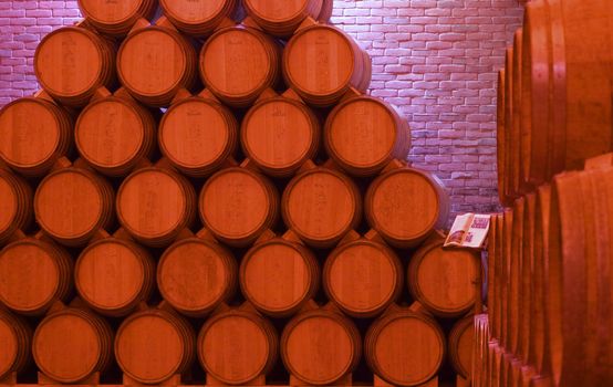 Pile of barrels of wine under red light