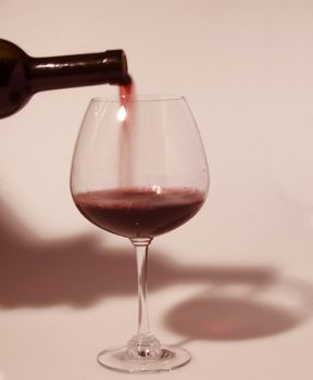 Bottle of red wine pouring in a glass