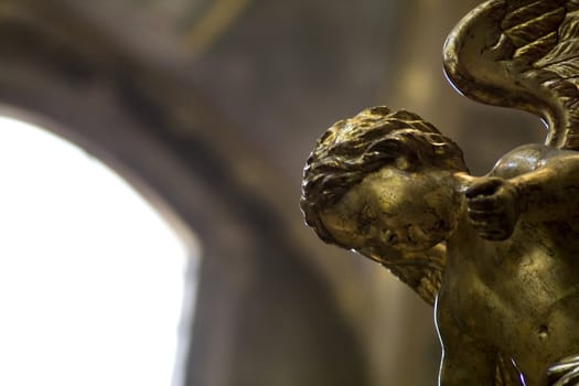 Little statue of a golden angel in a church