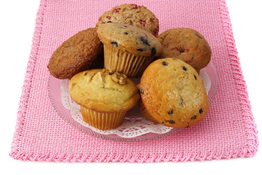 some muffins on a plate, pink tablecloth
