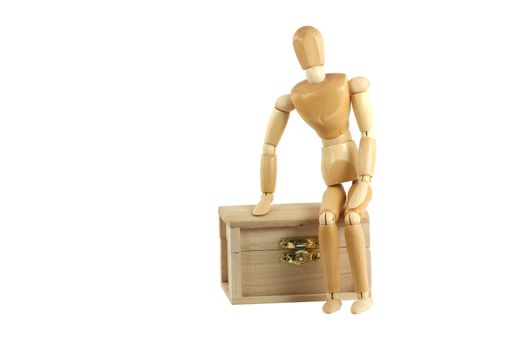 A Wooden manikin sitting on treasure chest