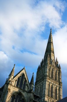 Salisbury Cathedral Spire against a cloudy, but blue sky background. Plenty of room for copy etc.