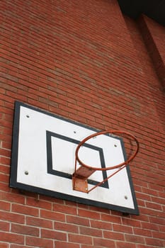A Basketball hoop set on a red bricked wall background