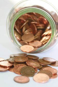 An open jar of pennies cascading from a jar
