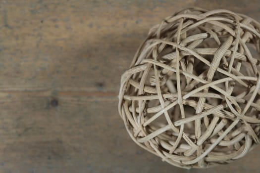 A twig sphere set against a wooden background. Abstract theme.