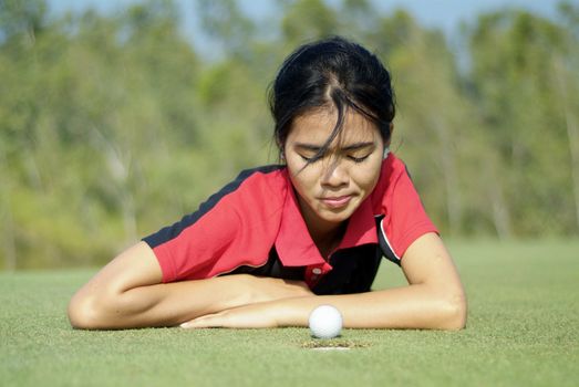 Young, female golf player and a golf ball that almost made it.