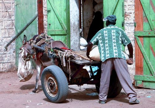 mauritani men carry a sack to a wagon in Atar Mauritania