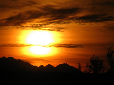 Arizona Desert Sunset captured with orange, black, and yellow skies.
