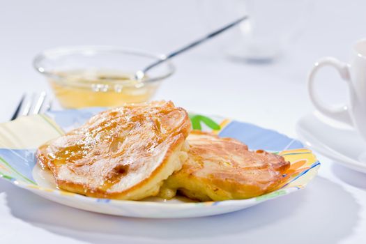 Two pancakes with honey on plate, lunch