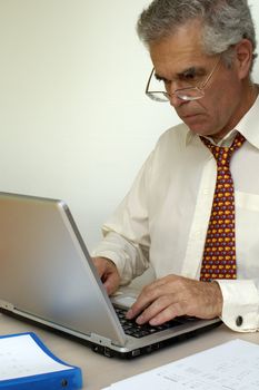 A mature businessman working at his laptop computer.