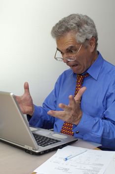 A businessman howls in frustration at his laptop. Now what's it doing? Space for text on the white background.