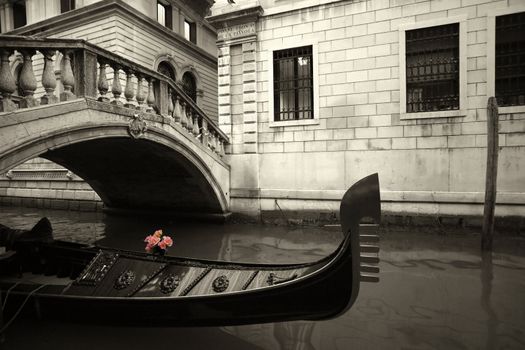 Pink flowers waiting on a rain covered gondola in Venice, Italy.
