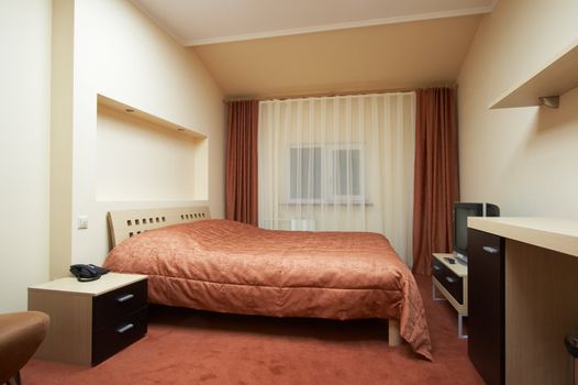 Bedroom in red tones in modern hotel