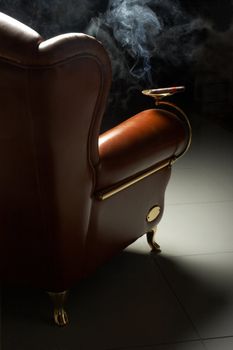 Cigar and beautiful leather armchair on marble to a floor