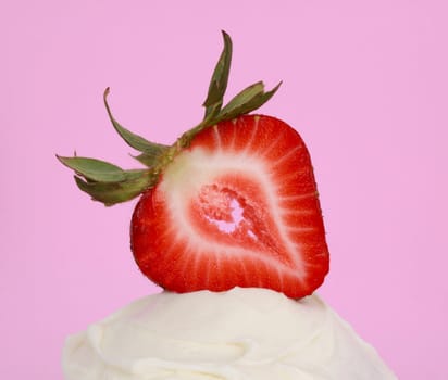 slice of fresh strawberry on sugar icing, pink background