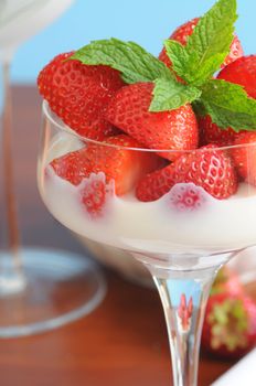 Red ripe strawberries served with cream and sugar.