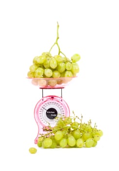 Kitchen Scales filled with green grapes isolated over white