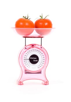 Kitchen Scales with fresh tomatoes isolated over white