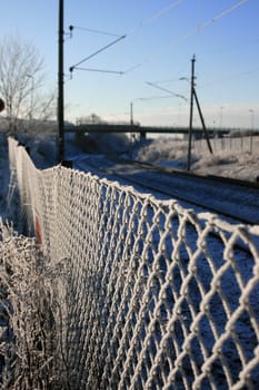 Icy fence with the railway in the background