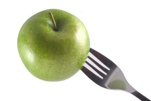 A green apple stuck on a fork, isolated on white.