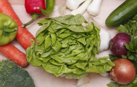 Upper view of fresh vegetables on a wooden chopping board.Selective focus on the green lettuce.