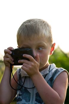 The child with the camera of outdoor in the summer evening