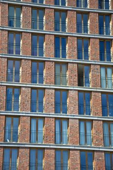 Fragment of the facade of the modern brick residential house with the same balcony. Detail.