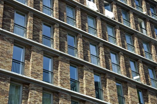 Fragment of the facade of the modern brick residential house with the same balcony. Detail.