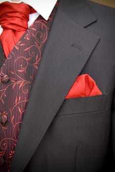 suit jacket of groom and red cravat ascot tie