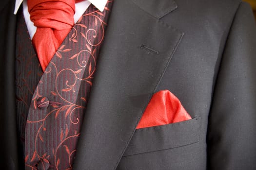 suit jacket of groom and red cravat ascot tie