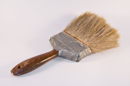 Old heavily used paint brush against white background