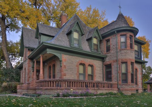 Avery house - historical landmark of Fort Collins, Colorado, at dawn against fall cottonwood foliage