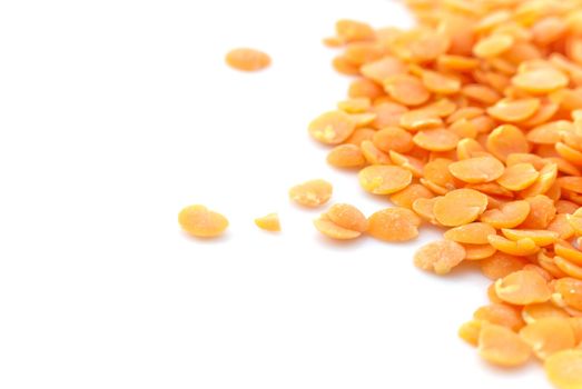 Macro (close-up) of red (orange) lentils isolated against white surface.