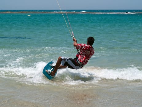 Kitesurfer in action of extreme sport on clear blue sea background