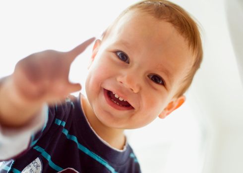 Closeup portrait of little boy smiling on white