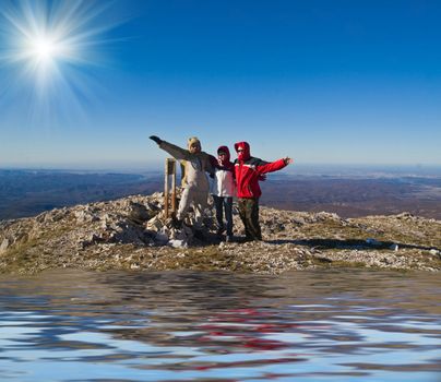 Happy hikers wave their hands  on mountain summit