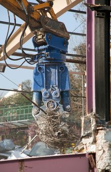 bulldozer in action, pulling ropes of steel on a building site