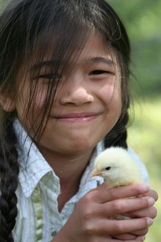 Little girl holding her yellow pet chick