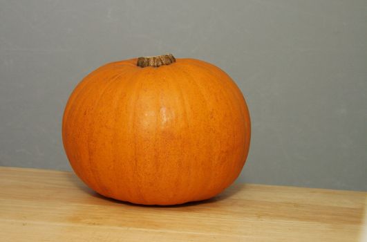 large whole pumpkin placed on a wooden table