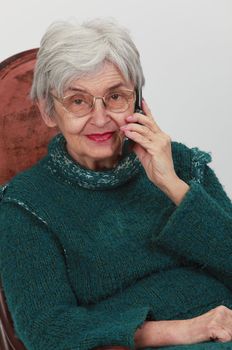 Portrait of an old woman using a mobile phone.